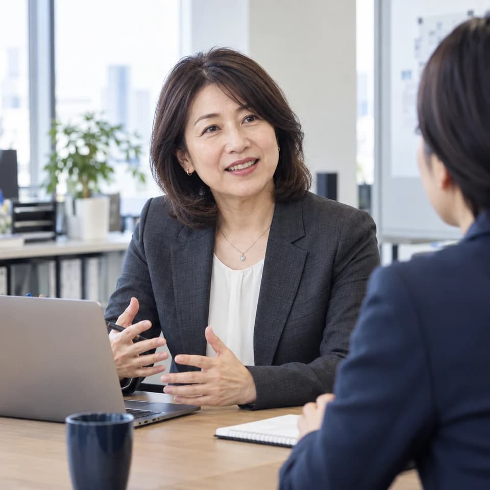 職場で同僚と仕事の進め方を話し合う管理職